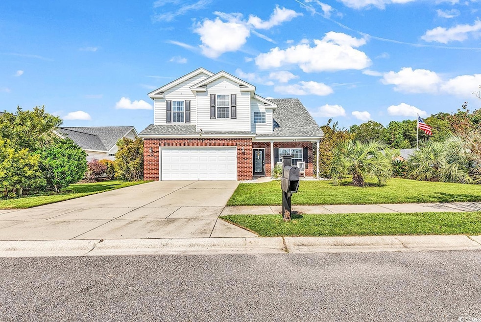 Traditional home with driveway, a front yard, an a