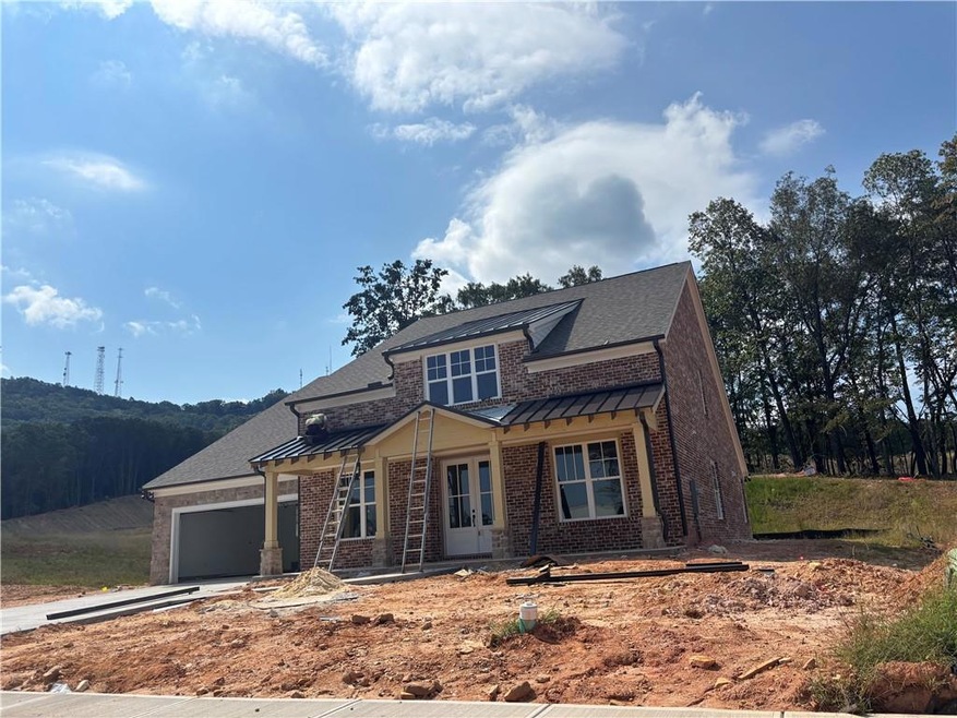View of front of home featuring brick siding, a standing seam roof, driveway, a garage, and a metal roof