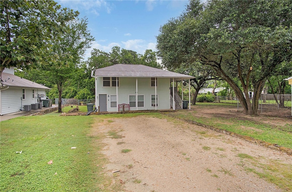 View of front of home featuring dirt driveway, fen