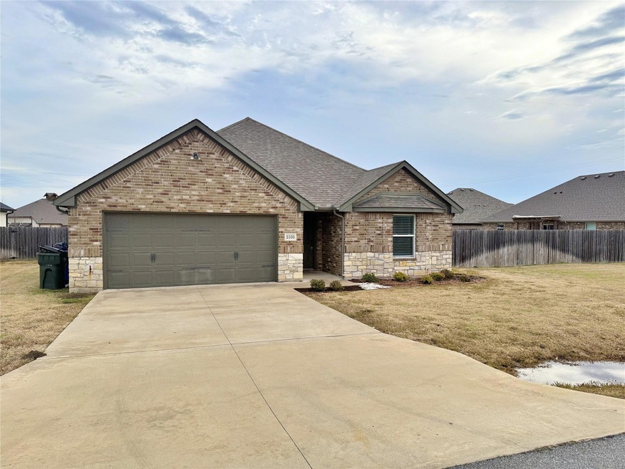 View of front of house featuring a front lawn and a garage