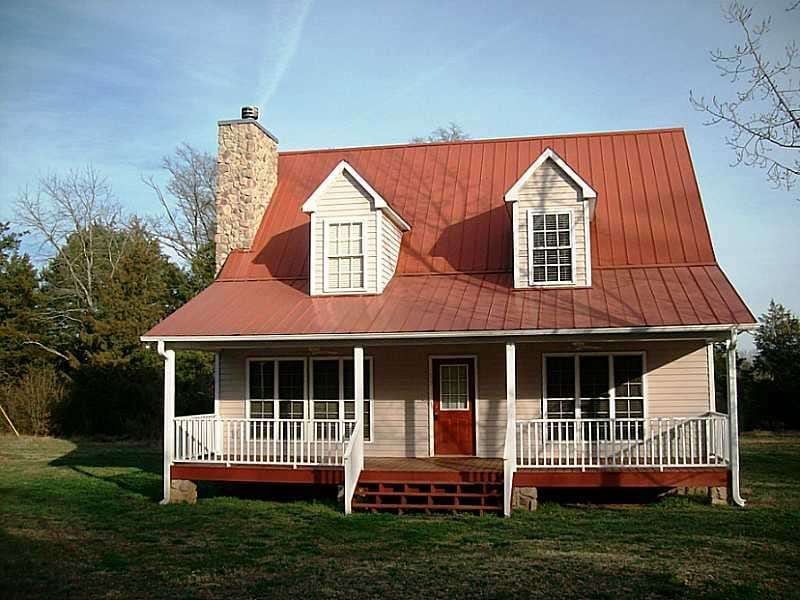Exterior Front. Home with stone fireplace & red me