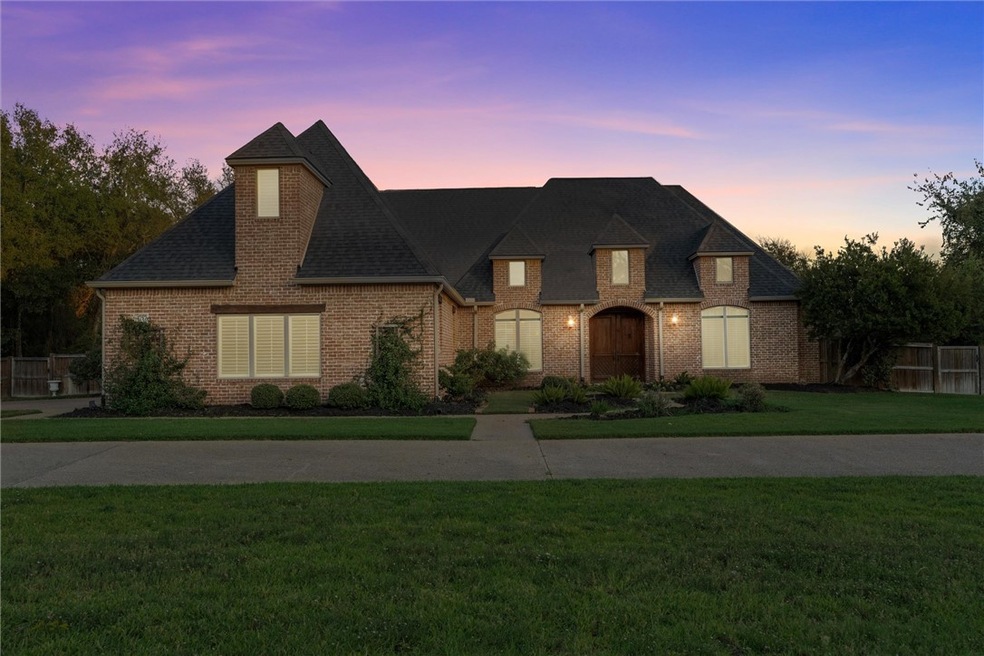 French country inspired facade with a lawn