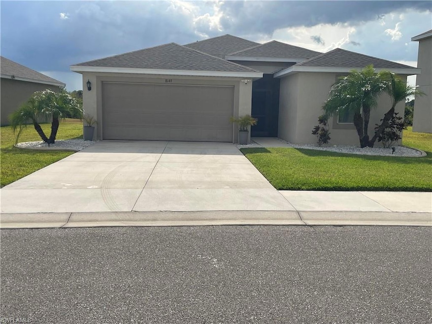 View of front of house with stucco siding, drivewa
