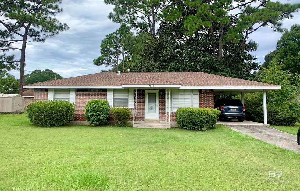 Single story home featuring a carport and a front yard