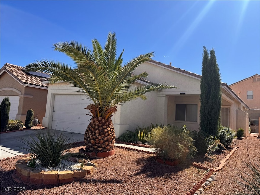 View of side of property with stucco siding, a garage, and concrete driveway