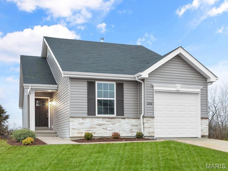 View of front of home with a garage and a front lawn