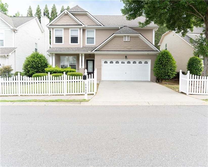 View of front of home with an attached garage, con
