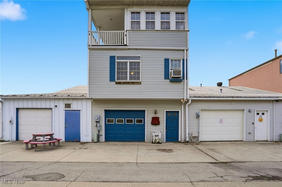 View of front of property featuring a garage, driveway, and a balcony