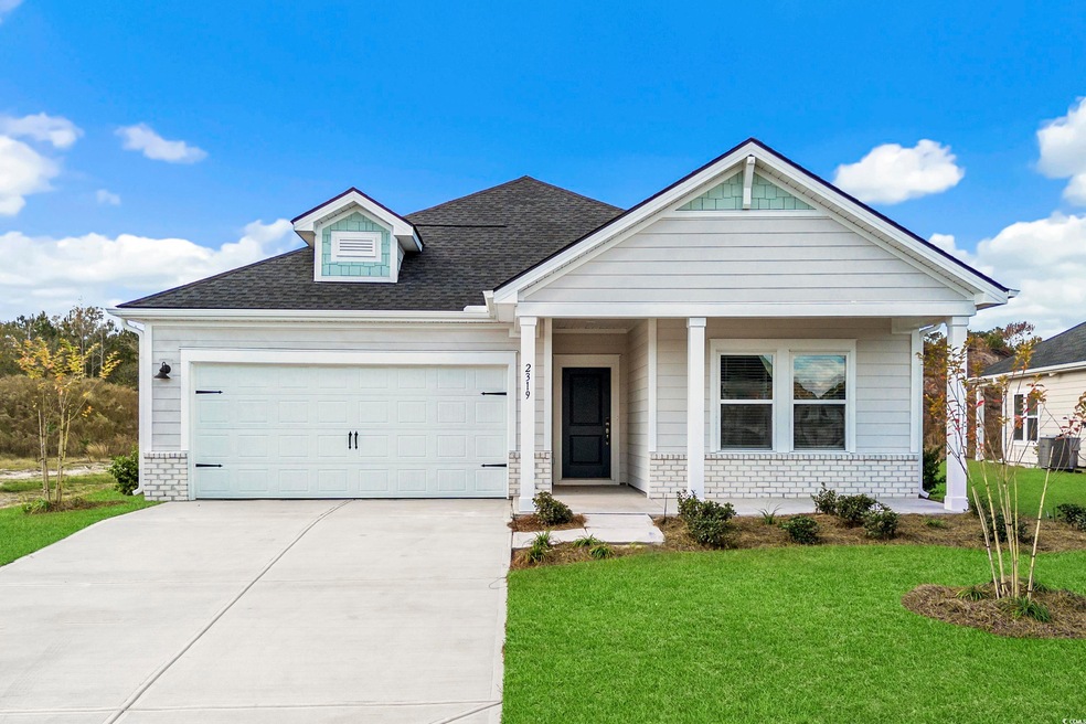 View of front of property with a front lawn, a porch, concrete driveway, an attached garage, and brick siding