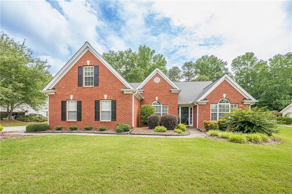 Traditional-style home with brick siding and a front lawn