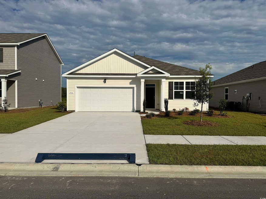 View of front of home with a front yard and a gara