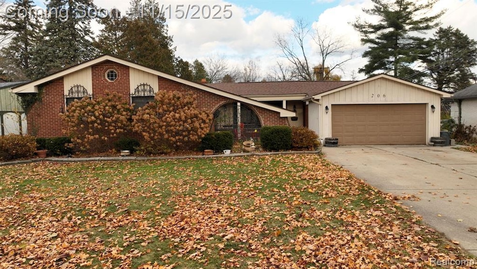 Ranch-style home with driveway, a garage, a front yard, and brick siding