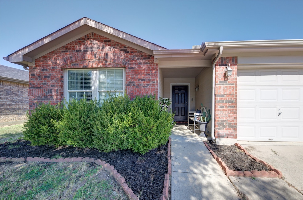 View of front of property with a garage and brick siding