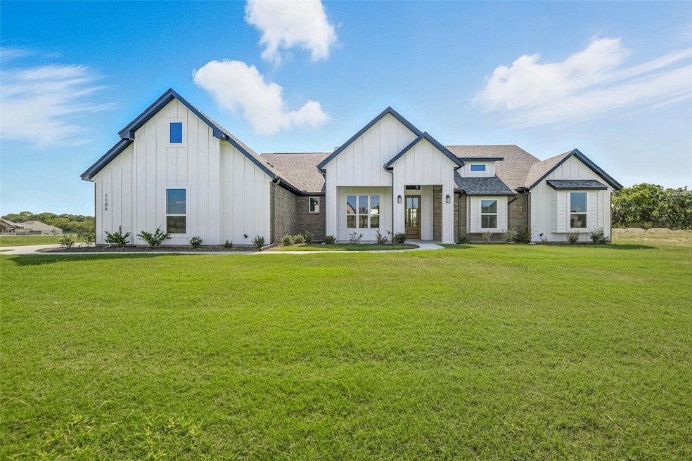 Modern farmhouse style home with board and batten siding, a front yard, and roof with shingles