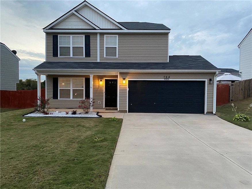 View of front of house with a porch, a garage, concrete driveway, and roof with shingles