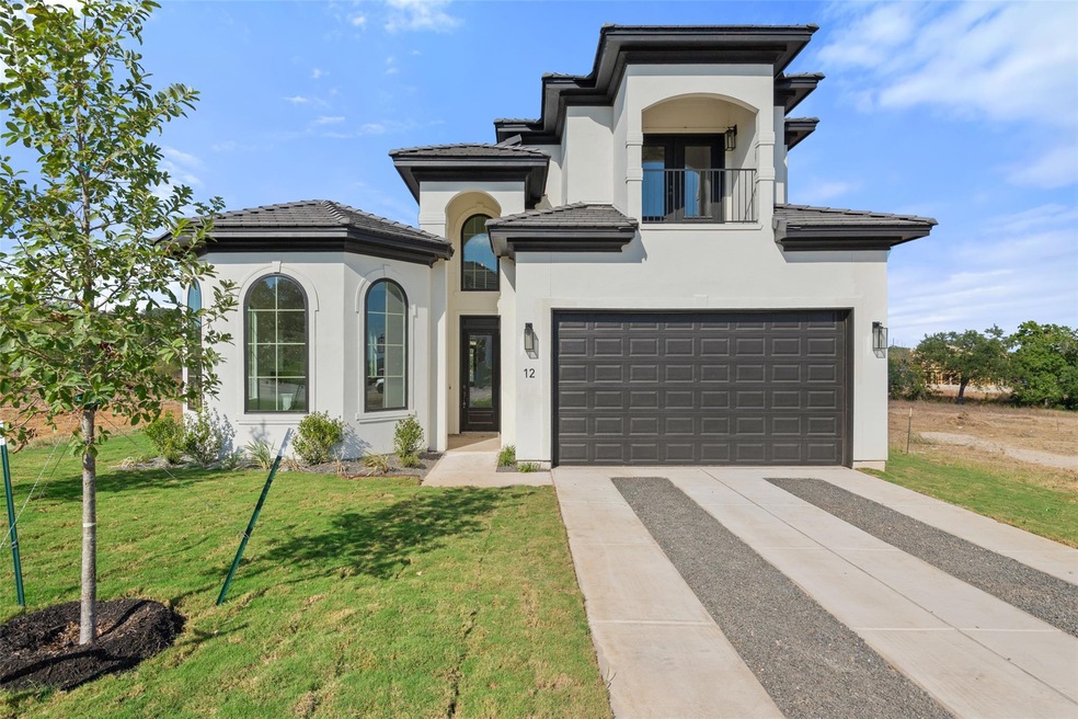View of front of home with a balcony, driveway, stucco siding, and a tiled roof