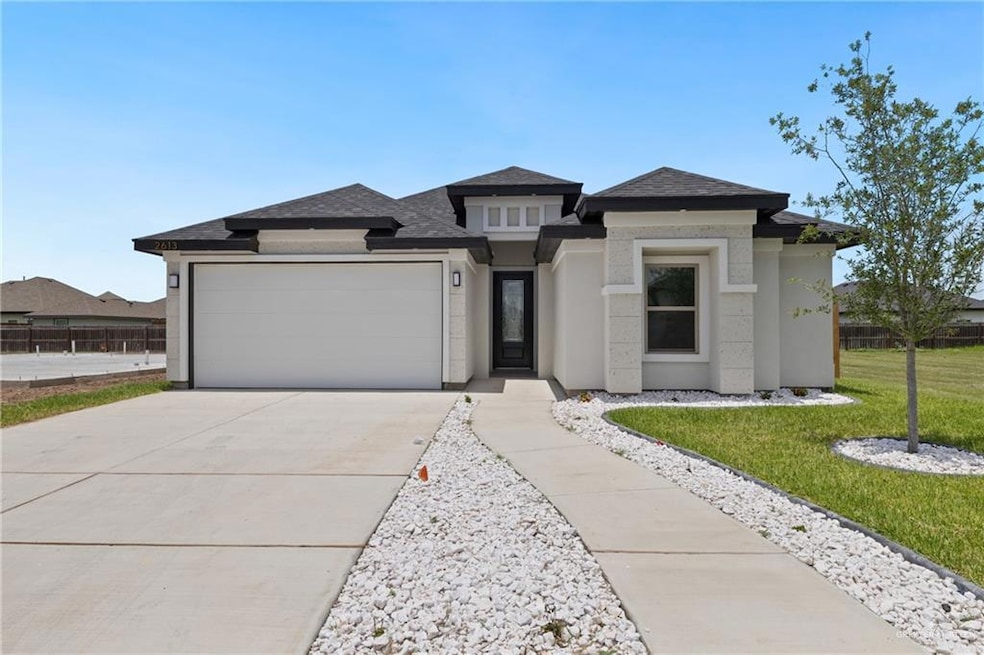 Prairie-style home featuring a garage, concrete driveway, stucco siding, a front lawn, and roof with shingles