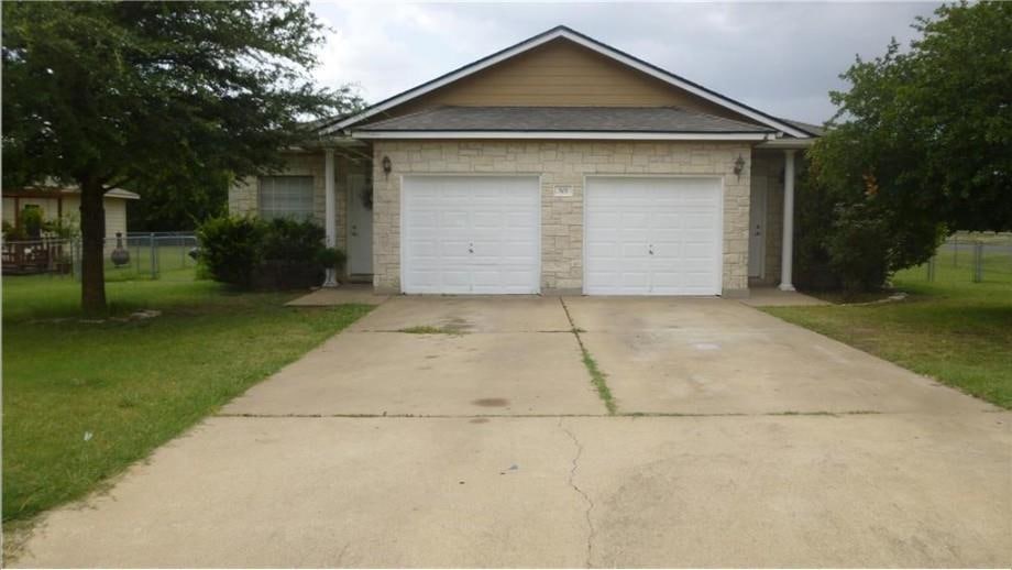 View of front of home with a garage, stone siding