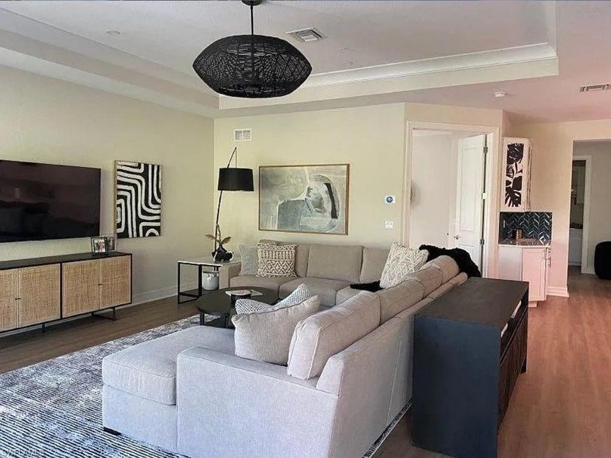 Living area featuring a tray ceiling, wood finishe