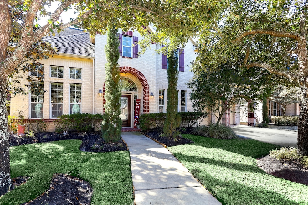 Front view of home nestled just on the other side of mature oak trees