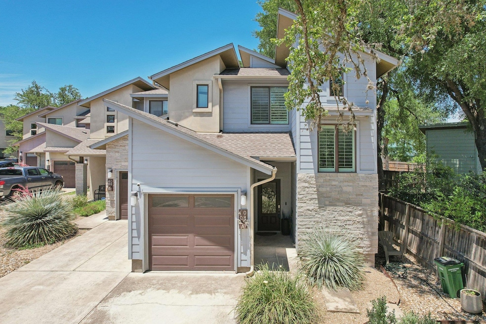 View of front of house with driveway, roof with s