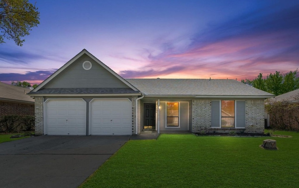 Ranch-style home with a garage, concrete driveway, a front lawn, and brick siding