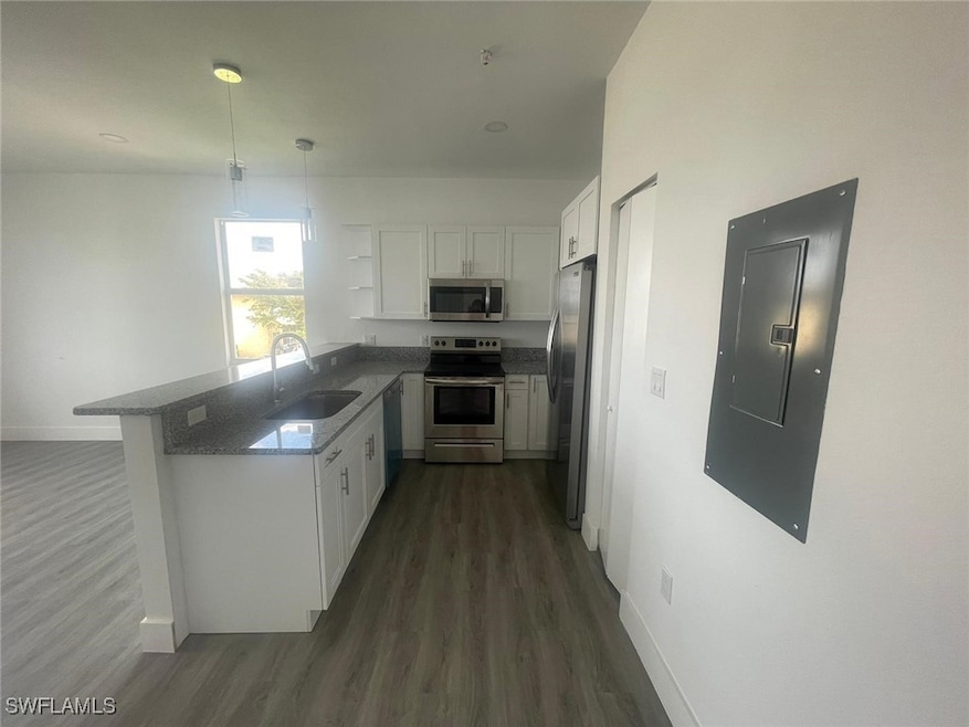 Kitchen with electric panel, a sink, white cabinet