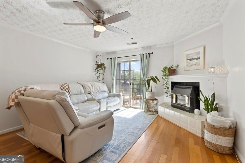Living room featuring crown molding, a textured ceiling, hardwood / wood-style flooring, ceiling fan, and visible vents