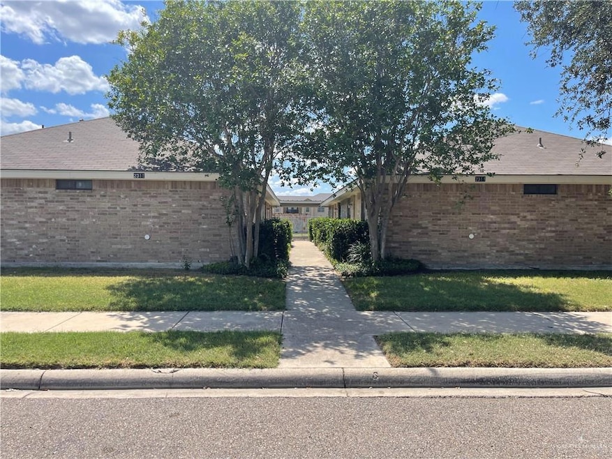 View of side of home featuring brick siding and a lawn