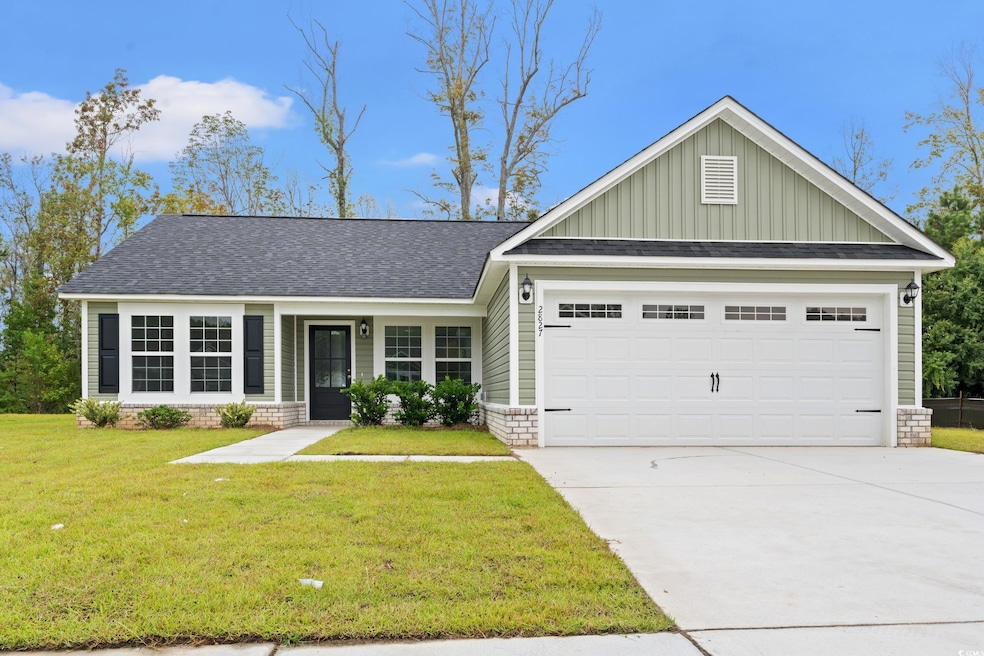 View of front facade featuring board and batten siding, a shingled roof, a front lawn, and driveway