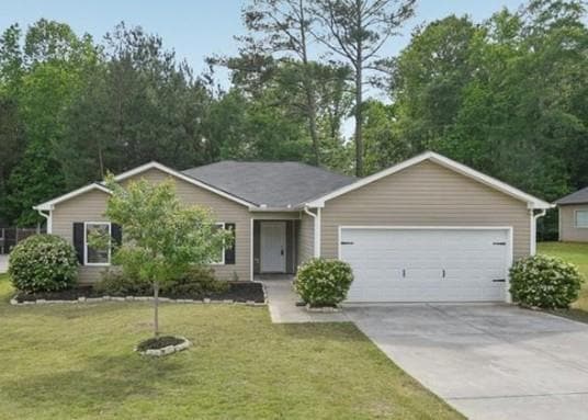 Single story home featuring an attached garage, driveway, and a front lawn