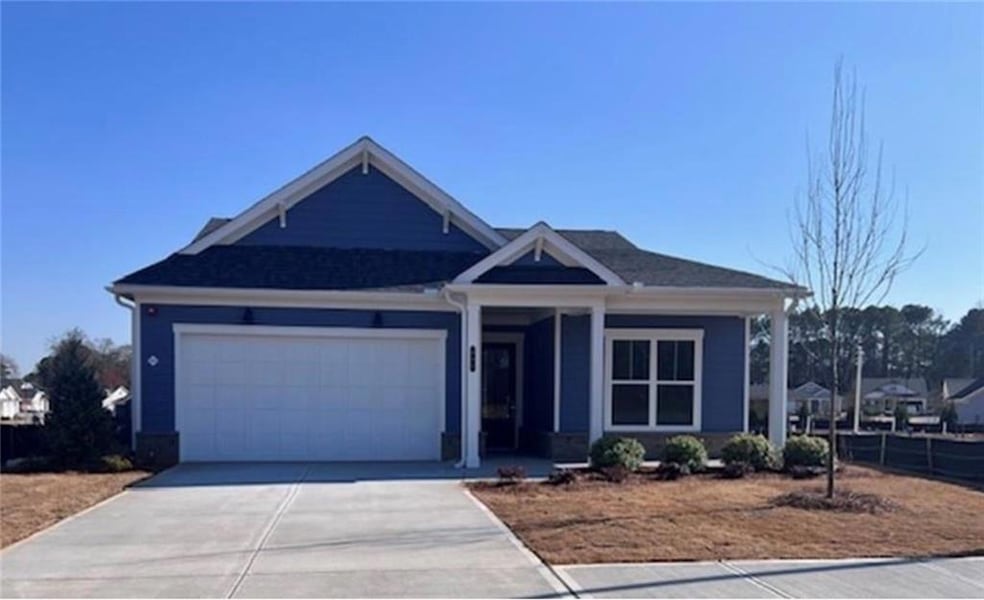 View of front of property featuring concrete driveway, an attached garage, and a porch