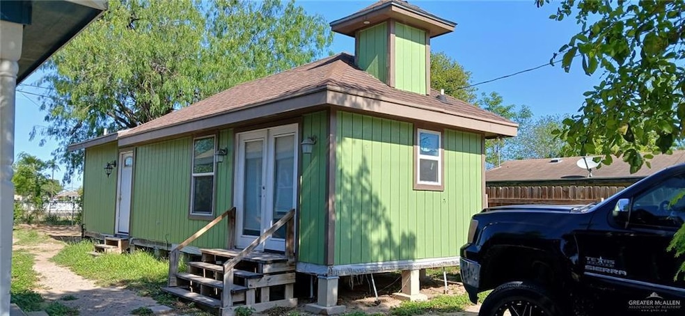 View of side of property with entry steps and roof with shingles