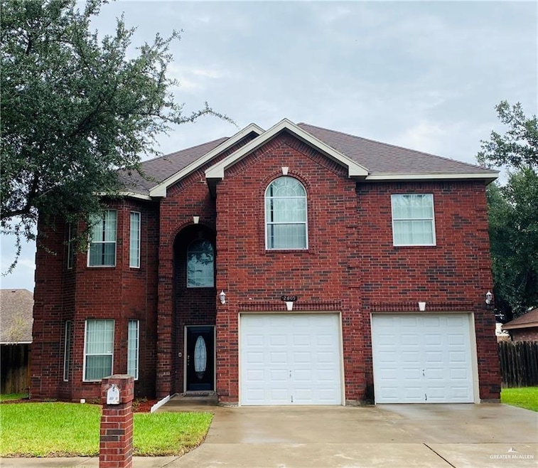 Traditional-style home featuring driveway, brick siding, and a garage