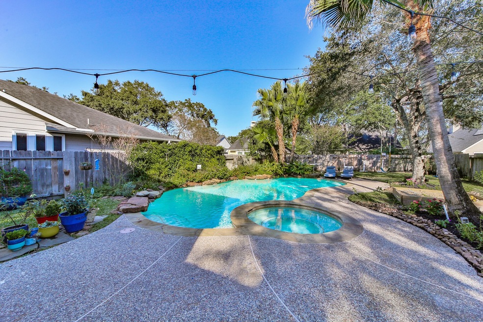 The perfect backyard with large patio, spa, and spacious pool with waterfalls!