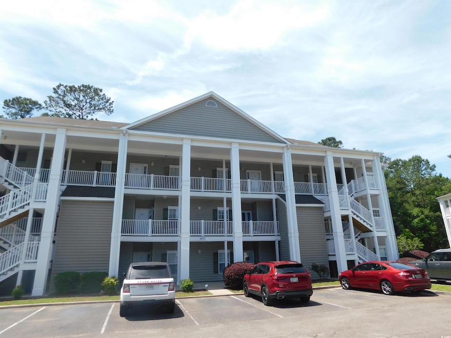 View of property with stairs and uncovered parking