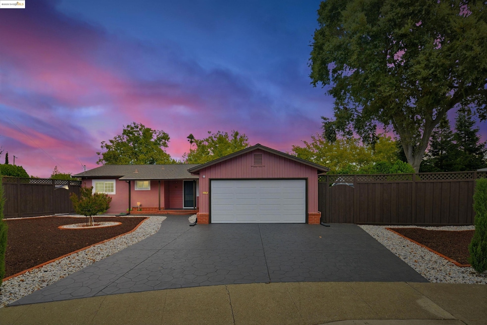 Ranch-style home with decorative driveway and an attached garage