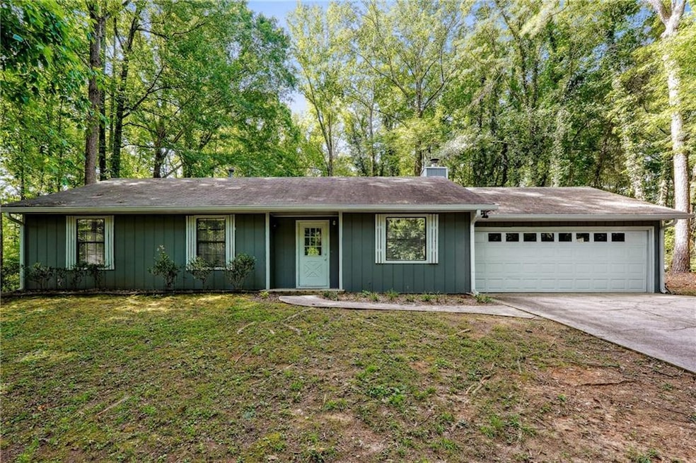 Ranch-style home with a garage and a front lawn