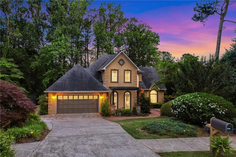 Traditional home featuring driveway, a garage, a shingled roof, and stone siding