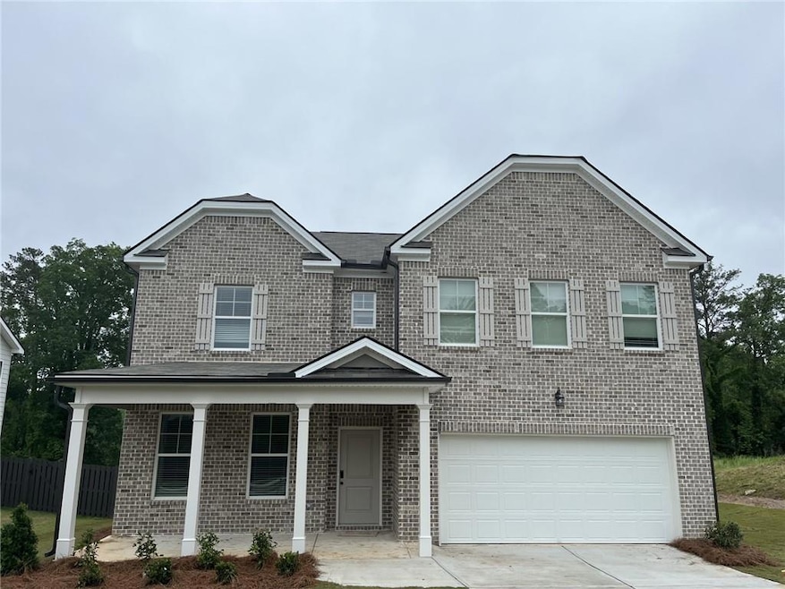 Traditional home featuring brick siding, covered p