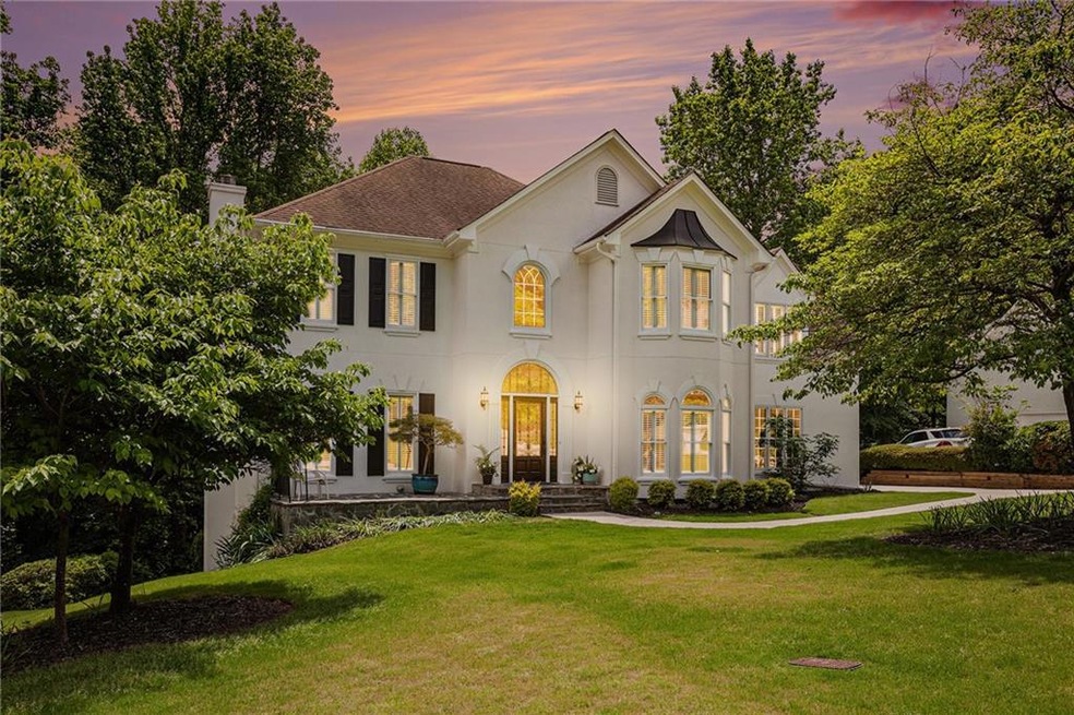 French country home featuring a chimney, stucco si