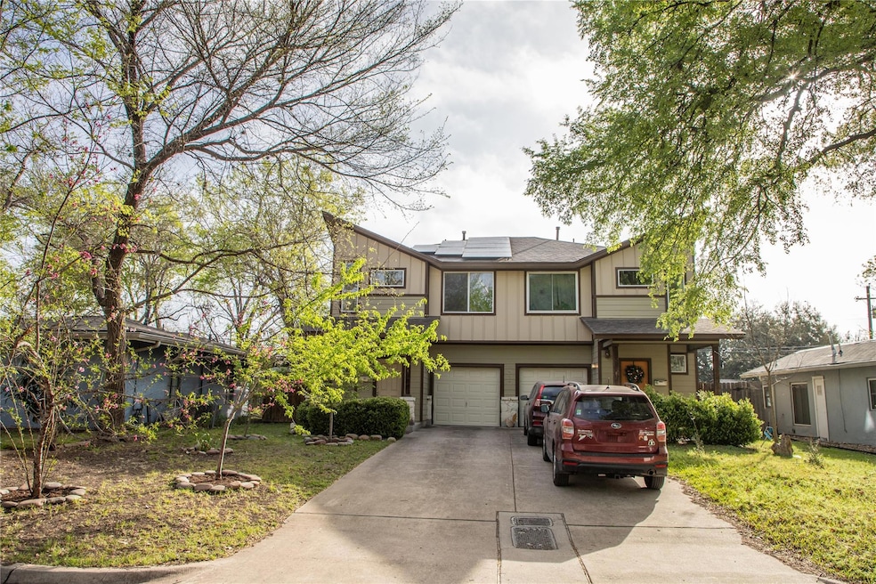 View of front facade featuring driveway, solar pa