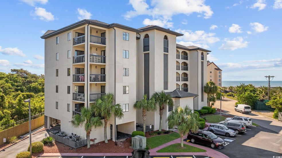 View of apartment building / complex with uncovered parking and fence