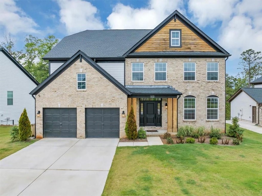 View of front of home with a front lawn, driveway, and brick siding