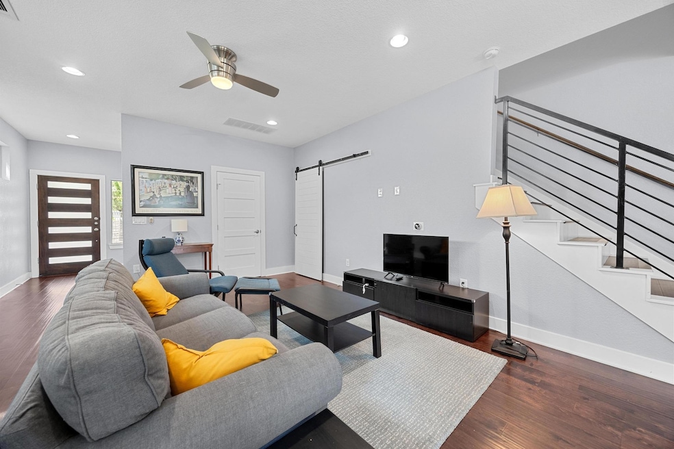 Living area featuring a barn door, a ceiling fan,