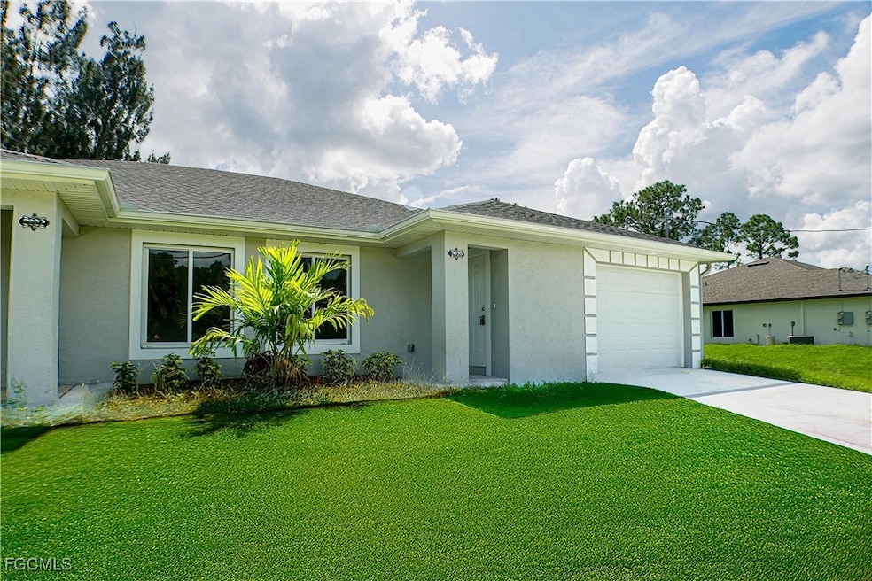 View of front of property with a front yard, stucco siding, an attached garage, driveway, and roof with shingles