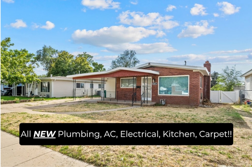 View of front facade featuring a chimney, brick siding, driveway, a gate, and covered porch