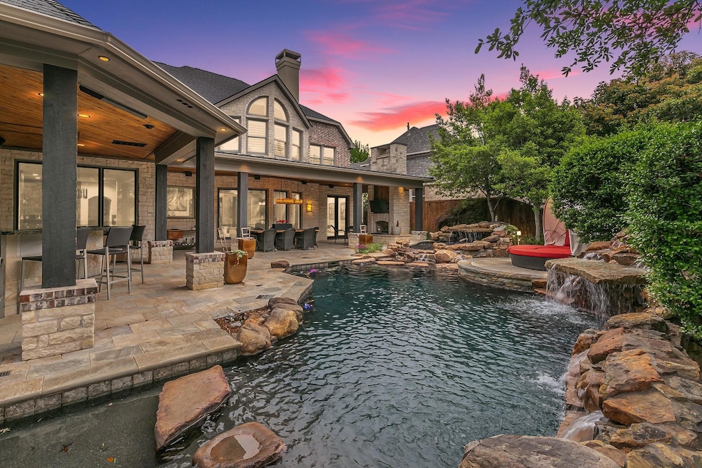 Pool at dusk with a hot tub, a patio, and pool wat