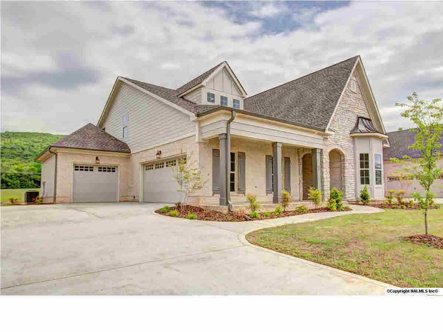 Charming French country elevation with an adorable front porch with stone accents.