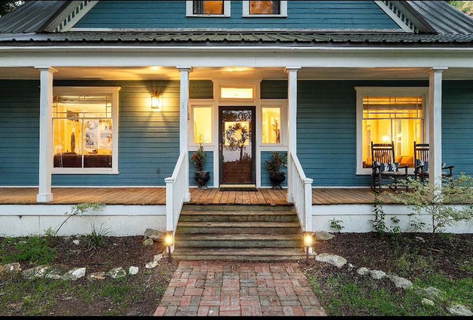 View of exterior entry with covered porch and met